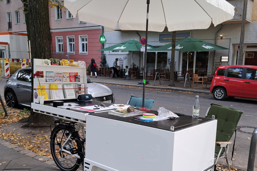 Foto vom mobilen Infostand - mit aufgeklapptem Schirm und vielen Info-Flyern